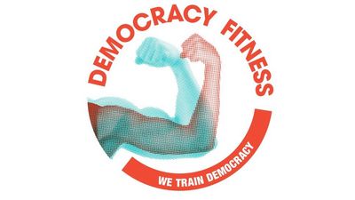 Geflexter Arm, rundherum in einem Kreis geschrieben "Democray Fitness - We Rain Democracy"