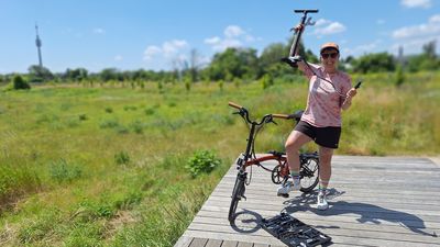 Eine Frau im sportlichen Outfit pumpt ihr Fahrrad auf.