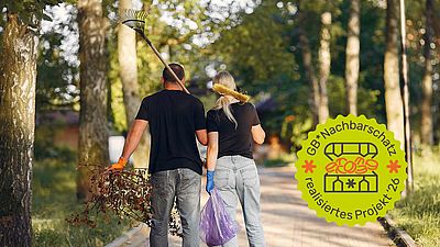 Zwei Menschen sind von hinten zu sehen, die einen Rechen und einen Müllsack halten.