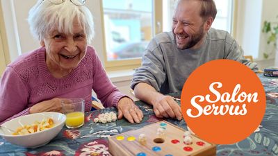 zwei Personen spielen das Spiel Schweinchen in der Grube. Sie lächeln und haben sichtlich Spaß.