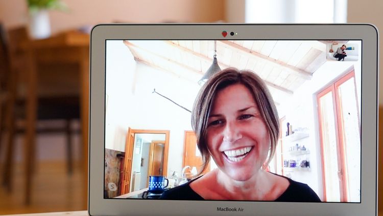 Christina Okresek Lachende Frau auf einem Laptop-Bildschirm