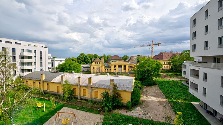 Blick auf Bestandsgesbäude und neue Wohnbauten