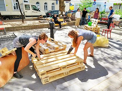 Aus Palettenholz wird eine Sitzbank gezimmert.