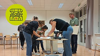 Eine Gruppe bearbeitet eine Holzplatte. 