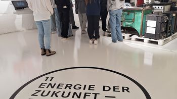 Raum mit Menschen und am Boden steht: Energie der Zukunft