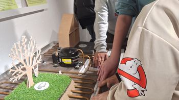 Personen betrachten Modell von Wärmepumpe