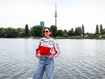 AYGYUL steht am Badesteg mit Blick auf den Donauturm.