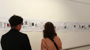 Zwei Personen betrachten Werke in der Ausstellung "Sprachen in Bildern"