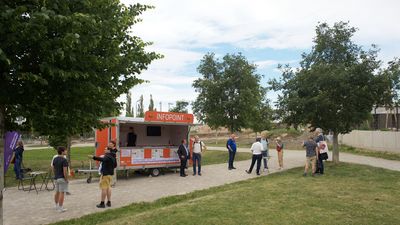 GB*Infopoint Aspanggründe einige Besucher*innen in lockeren Gruppen vor dem GB*Infopoint im Leon-Zelman-Park