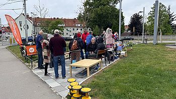 grüne Wiese und Weg, ca. 20 Personen draußen, Tische