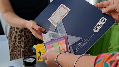 Schulsachen werden von einer Person ausgeteilt.