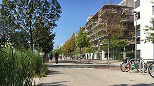 Zusammenleben und Nachbarschaft Fußgänger zwischen Park und Wohnhäusern