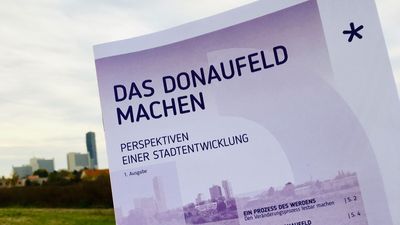 Magazin "Das Donaufeld machen" vor Hintergrund mit Wiese und Uno-City.