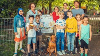Direktorin Gabriele Demel, Lehrerin Michaela Stemmer und junge Bücherwürmer der OVS Märzstraße präsentieren die Büchertasche beim Matznergarten.