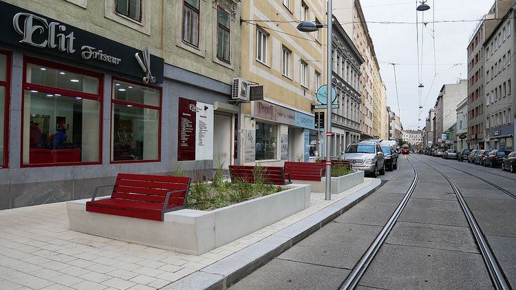 Blick entlang der Neulerchenfelder Straße mit neuer Gehsteigvorziehung und weinroten Bänken.