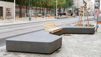 Moderne Stadtmöbel zum Sitzen aus Beton und Holz auf einem Gehsteig