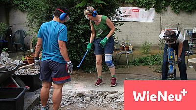 Das Bild zeigt 3 Personen, die mit unterschiedlichen Werkzeugen einen Innenhof entsigeln und dabei den Boden aufstemmen.