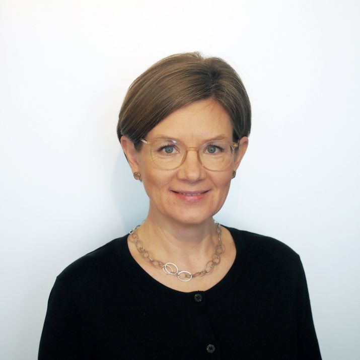 Nina Chladek-Danklmaier ein Portrait einer Dame in einem schwarzen Pullover vor einer weißen Wand