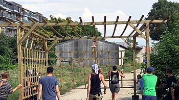 Eine Pergola wird von 6 Personen getragen.