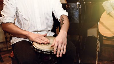 Ein Mann spielt auf einer Trommel.