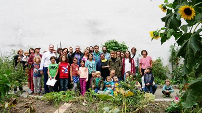 Lambertgarten Im Vordergrund ein Beet, im Hintergrund eine Gruppe an etwa 20 Personen
