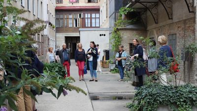 Innenhof im 8. Bezirk Eine Gruppe von Menschen in einem Innenhof mit Bepflanzung