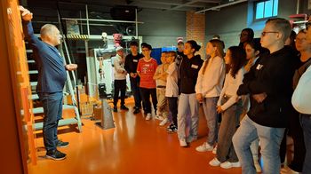 Gruppe junger Menschen steht in Museum und hören Person zu