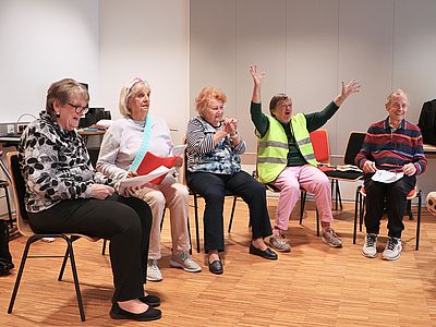 5 Mitglieder der Bühnengoldies sitzen im Halbkreis und üben ihre Texte.