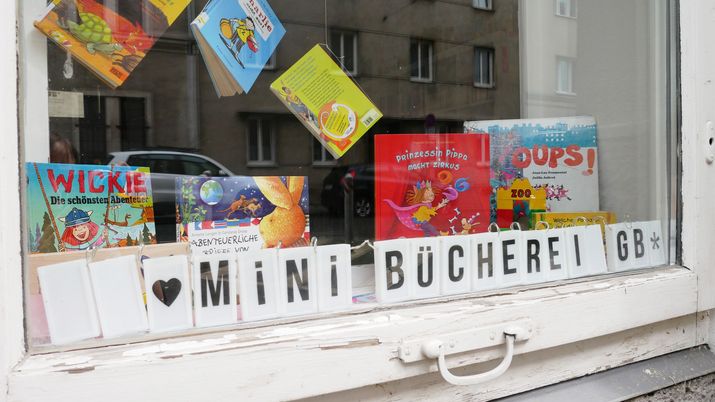 Minibücherei im Stadtteilbüro Man sieht eine Auslage mit Büchern und der Aufschrift "Mini-Bücherei"