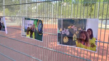 ein Foto von einem Zaun, auf dem einige Bilder vom Klimafest hängen