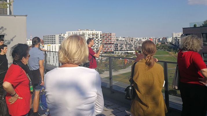 Besucher*innengruppe auf der Dachterasse des Wohnprojekts sovieso
