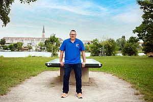 Michael Mader von Tischtennis Hobby Wien lehnt an einem Tischtennistisch in einem Park.
