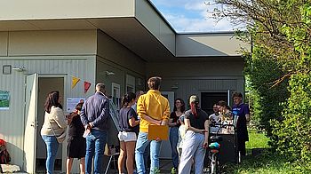 Mehrere Personen auf der Terrasse des Gemeinschaftshauses.