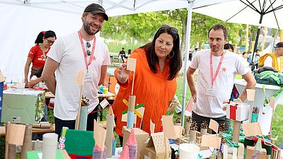 Drei Personen im Bild beim Betrachten eines Architekturmodells - Vizebürgermeistern Kathrin Gaál und zwei Mitarbeiter der Gebietsbetreuung Stadterneuerung beim Tag des Wiener Wohnbaus