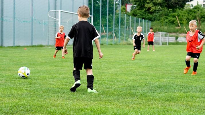 Buben beim Fußball speilen auf einem Fußballfeld