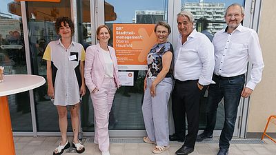 Fünf Personen stehen vor dem neuen Stadteilmanagmentlokal im Oberen Hausfeld
