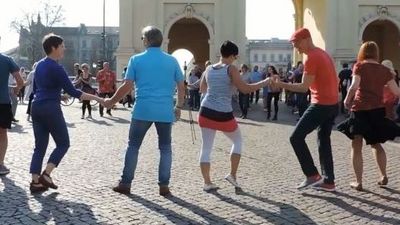 Menschen tanzen auf einem öffentlichen Platz in einem Kreis