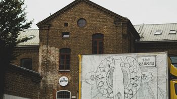 Schwarz-weißer LKW vor altem Backsteinhaus mit Aufschrift "100 Blumen"