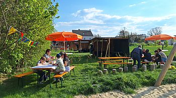 Garten mit Heurigentischen und Schirmen. 