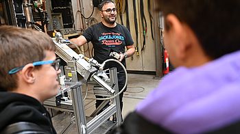 Person männlich gelesen präsentiert technisches Gerät