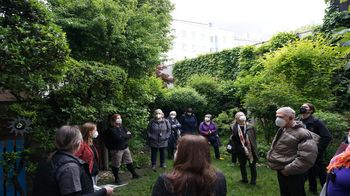 Tourbesucher*innen in einem begrünten Innenhof in Margareten