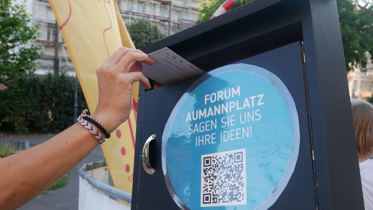 Eine Hand wirft eine Karte in einen Postkasten