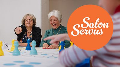 Zwei Damen spielen angeregt und vergnügt ein Gesellschaftspiel.