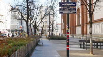 Begrünter, urbaner Platz neben einer Backsteinkirche