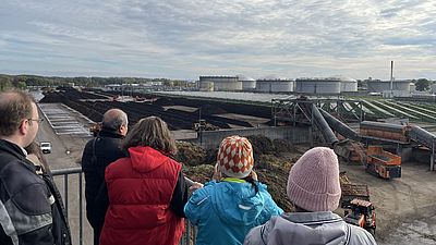 Menschen blicken auf das Kompostwerk