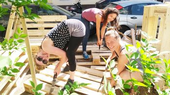 Drei Frauen beim Bau eines Möbels aus Holzpaletten