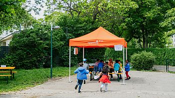 Kinder rennen zu Pavillon am Mitmachtag.