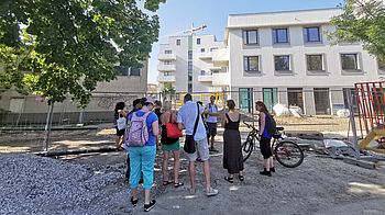 Menschengruppe bei Führung über die Baustelle Neu Leopoldau