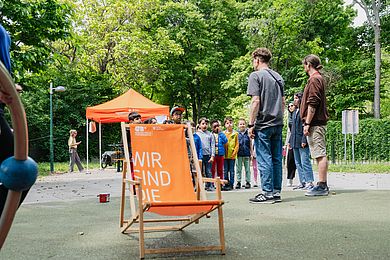 Liegestuhl mit Kindern im Hintergrund