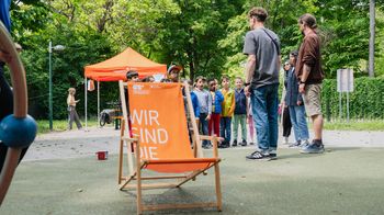 Liegestuhl mit Kindern im Hintergrund